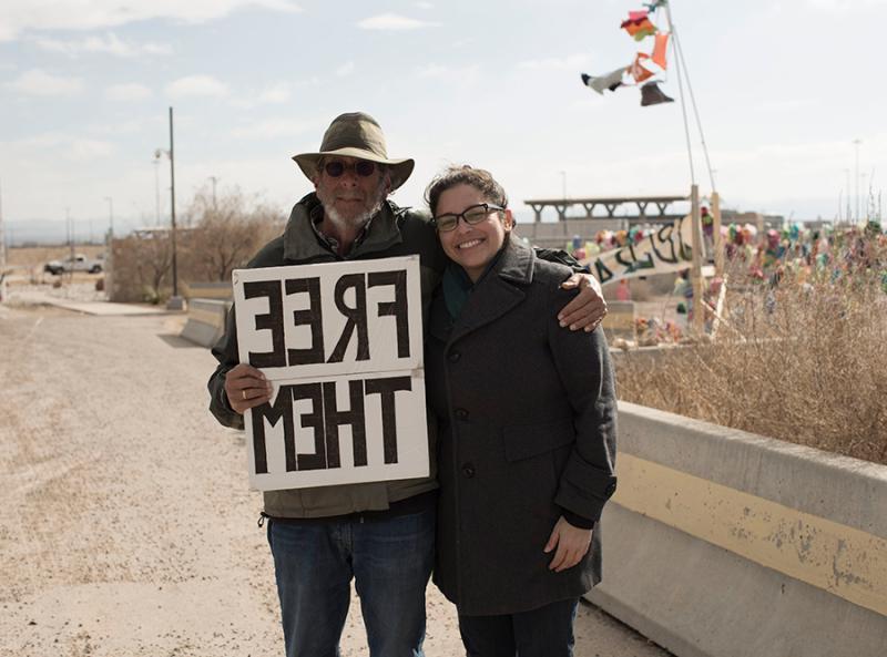Tania Romero and Joshua Rubin holding a sign reading "Free Them"
